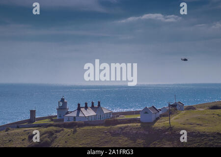 Küstenwache Hubschrauber über Anvil Point Lighthouse in Durlston Country Park, Swanage, Dorset, Großbritannien Stockfoto