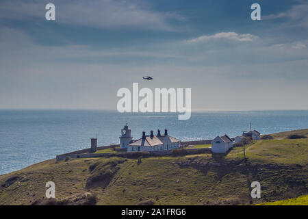 Küstenwache Hubschrauber über Anvil Point Lighthouse in Durlston Country Park, Swanage, Dorset, Großbritannien Stockfoto