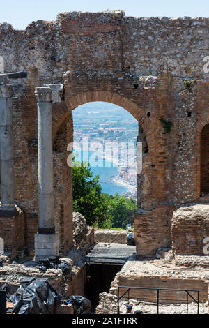 Panoramablick auf die schöne Küste des Mittelmeeres durch den Bogen von der antiken griechischen Theater in Taormina, Sizilien, Italien. Stockfoto