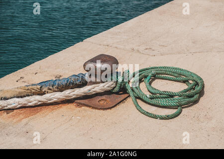 Seil von einem Schiff oder Boot festgebunden an einen Poller am Hafen closeup - Stockfoto