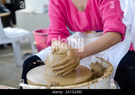 Keramische Arbeiten mit Lehm Töpferscheibe, aus der Nähe. Die Frau ist Töpfern im Studio. Stockfoto