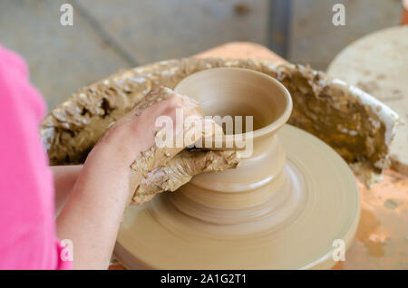 Keramische Arbeiten mit Lehm Töpferscheibe, Ansicht von oben. Die Frau ist Töpfern im Studio. Stockfoto