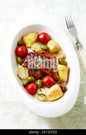 Gebratene Entenkeule mit Ofen gebackenes Gemüse und Oliven Stockfoto