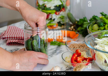 Gurken mit Knoblauch, Salz und Dill zum Beizen. Gurken im Glas, hausgemachte Gemüse. Stockfoto