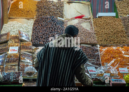 Mann in djellaba Verkaufen getrocknete Früchte und Nüsse auf dem Platz Jemaa el Fna in Marrakesch in Marokko Stockfoto