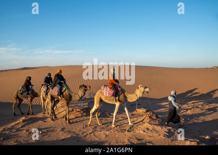 Gruppe von Touristen auf dem Kamel Safari in der Wüste von Marokko Stockfoto