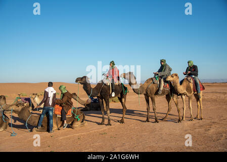 Gruppe von Touristen auf dem Kamel Safari in der Wüste von Marokko Stockfoto