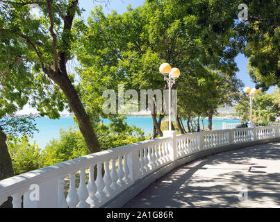 Blick auf blaue Wasser im Meer durch weiße Steinbrüstung von der Promenade an einem sonnigen Tag in Velvet Saison. Dekorative Architektur Bau. Stockfoto