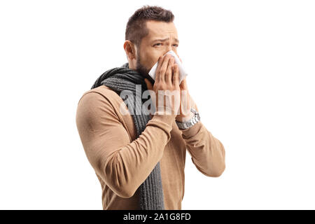Junger Mann mit Schal Niesen und blasen Nase auf weißem Hintergrund Stockfoto