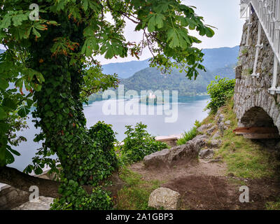 Bleder See mit der Marienkirche auf der Insel. Sonnenlicht spiegelt sich in der See in einem bewölkten Tag. Stockfoto