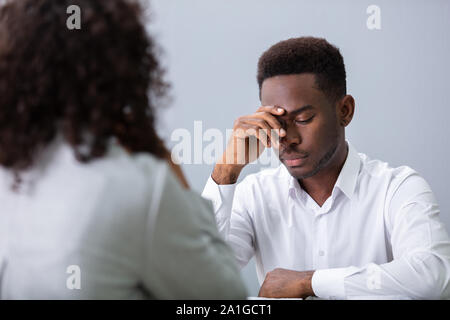 Betont Young Business Mann hält seinen Kopf an Interview im Büro Stockfoto