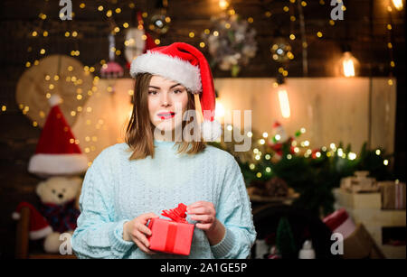 Frau santa claus hat am Heiligabend. Lady adorable nettes Gesicht feiern Weihnachten zu Hause. Mädchen stilvolle Make-up rote Lippen zu Weihnachten wünschen. Gemütliche Weihnachtsstimmung. Glaube an Wunder. Stockfoto