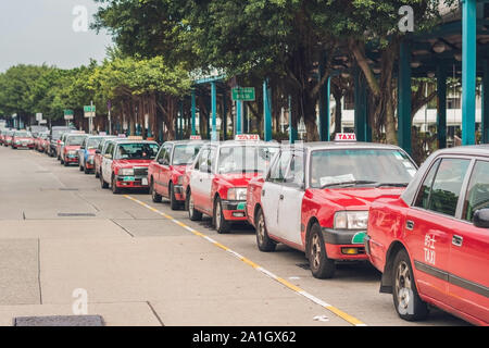 Eine Flotte von Hong Kong Taxi an einem Taxistand wartet. Hong Kong Taxis sind leicht erkennbar an ihren roten und weißen Farben. Die generischen chinesischen Text auf Stockfoto