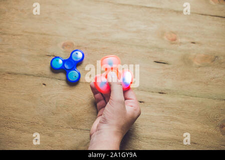 Ein Mann Hand hand Spinner oder zappeln Spinner über Holz- Hintergrund. Stockfoto