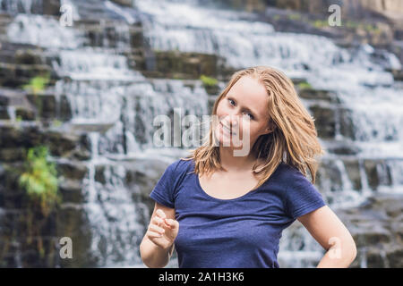 Junge Frau, Wanderer, Touristen auf dem Hintergrund der erstaunliche Pongour Wasserfall ist berühmt und schönsten Herbst in Vietnam. Nicht weit von Dalat Stadt est Stockfoto