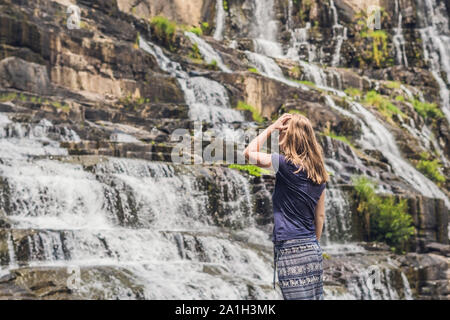 Junge Frau, Wanderer, Touristen auf dem Hintergrund der erstaunliche Pongour Wasserfall ist berühmt und schönsten Herbst in Vietnam. Nicht weit von Dalat Stadt est Stockfoto