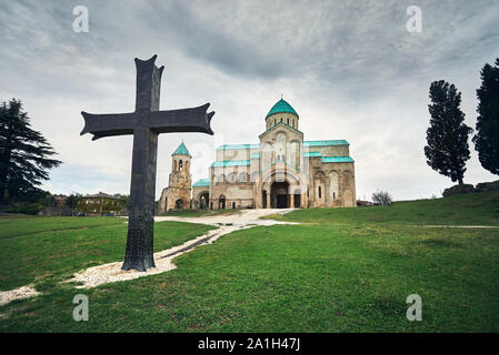 Big Iron Cross vor bagrati Kirche bei bedecktem Himmel in Kutaissi, Georgien Stockfoto