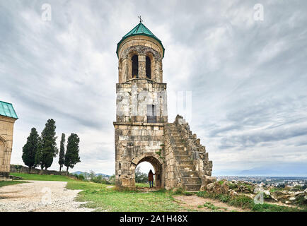 Frau touristische im Bogen der Kapelle Turm von bagrati Kirche bei bedecktem Himmel in Kutaissi, Georgien Stockfoto