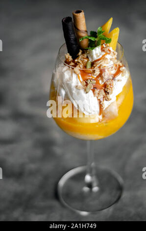 Bio Mango und Passionsfrucht tropische Eisbecher in Wein Glas Stockfoto