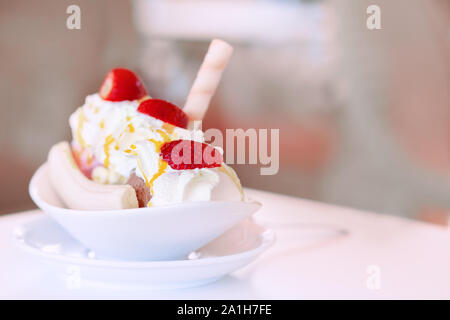 Dessert Sahne, Erdbeeren und Bananen auf einem Tisch in einem Café. - Nahaufnahme, selektiver Fokus, den freien Speicherplatz auf der rechten Seite Stockfoto