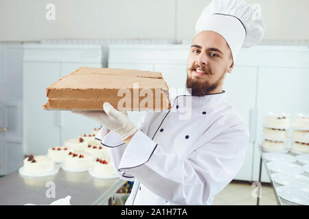 Konditor Mann mit Kuchen in der Konditorei lächelnd Stockfoto