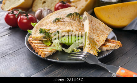 Ideen für ein köstliches Frühstück. Omelette mit Brokkoli auf geröstetem Brot. Mediterrane frittata Küche. Käse, Tomaten, Salat, Eis. Lecker und Stockfoto