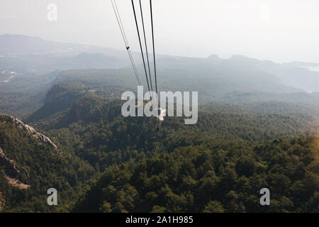Blick auf die Berge von der Kabine mit der Seilbahn auf die Spitze des Tahtali und das Meer in der Nähe der Küste von Kemer, Antalya, Türkei Stockfoto