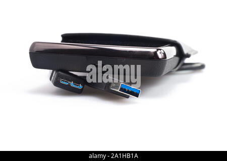 a portable harddisk in  soft leather case and USB cable on white background Stockfoto