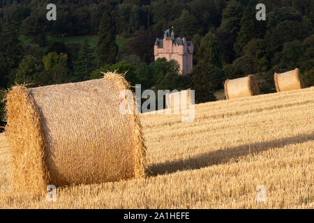 Ein Blick in Richtung Craigievar Castle in Aberdeenshire mit Strohballen im Vordergrund. Stockfoto