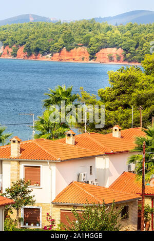 Nikiti, Sithonia, Chalkidiki, Griechenland Halbinsel Panorama mit Häuser, blaue Meer und die roten Felsen und Berge Stockfoto