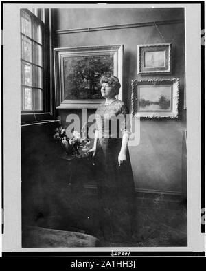 Frau Woodrow Wilson (Ellen Louise Axson), full-length Portrait, stehend durch die Fenster im Zimmer mit Gemälden, nach links Stockfoto