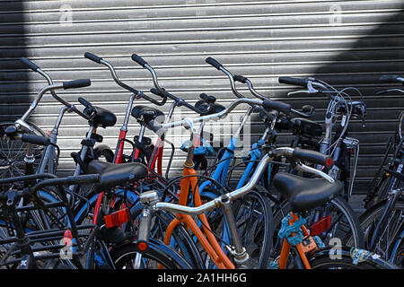 Groningen, Niederlande - 2019.09.21: Fahrräder vor einem schwarzen Shutter geparkt auf poelestraat Stockfoto