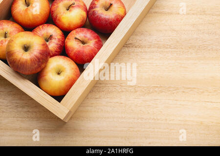 Frische rote apple Hintergrund mit kopieren. Äpfel in der Kiste auf hölzernen Tisch. Fuji apple Stockfoto