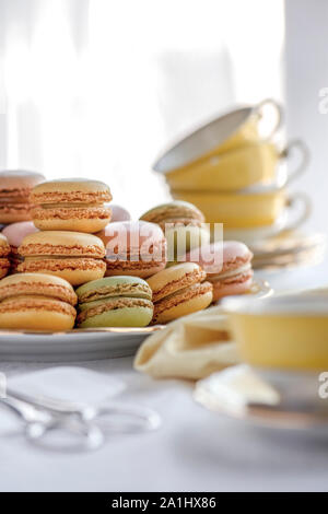 Selektiver Fokus einer Platte voller Macarons in der Nähe der hübschen gelben Tassen im Hintergrund Bilder mit Kopieren und Platz für Text-overlay Stockfoto