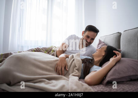 Junge glückliches Paar im Bett in den Morgen. Stockfoto