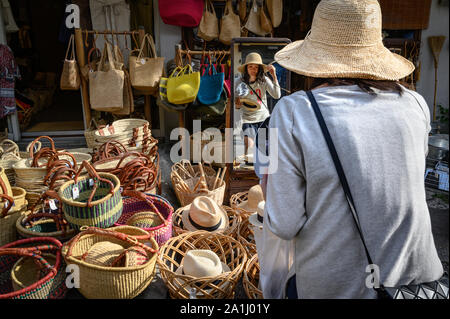 Eine junge Frau, die versucht, auf Hüte, yanaka Ginza, Tokyo, Japan Stockfoto