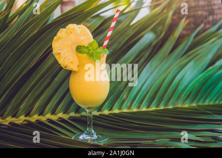 Ananas und Ananas smoothies vor dem Hintergrund einer Filiale einer Palme. Stockfoto