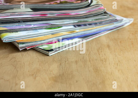 Stapel von bunten Zeitschriften auf dem Holztisch. Kopieren Sie Platz. Mockup für Design. Stockfoto