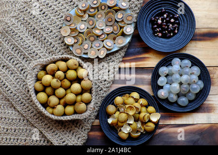 Sicht von oben Vietnamesischen tropischen Süß, wässrige Fruchtfleisch Obst, Longan Früchte Fleisch in transluzent Weiß, Schwarz, Gelb Schale, in der Hälfte der Dragon eye fr Schnitt Stockfoto