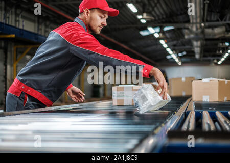 Lagerarbeiter arbeiten an einer Förderstrecke Stockfoto