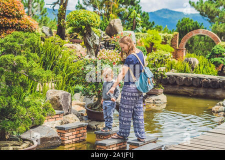 Mutter und Sohn zu Fuß die Felsen auf der anderen Seite des Flusses. Stockfoto