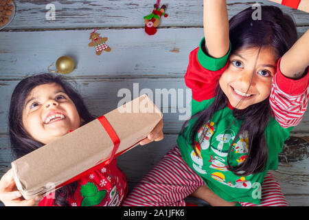 Kleinen Schwestern ihre Geschenke zu Weihnachten öffnen Stockfoto