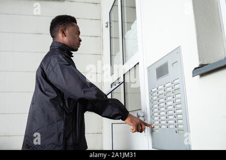 Mann, der vor dem Haus Klopfen die Tür Stockfoto
