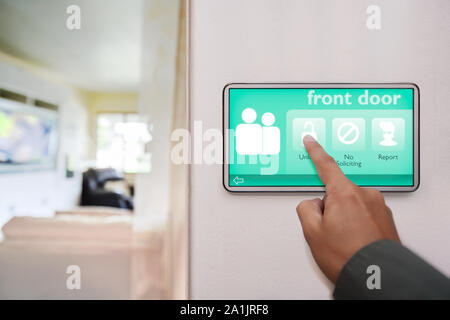 Home Eigentümer Entriegelung der vorderen Tür von zu Hause, mit einem Touchscreen Alle angeschlossenen Smart Home Funktionen zu kontrollieren. Stockfoto