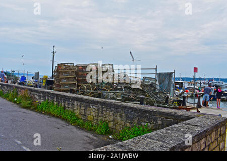 Blick auf den Hafen von Poole Haven Marina mit Angeln waren, wie Netze, Krabben und Hummer Töpfen auf Kai. Kleine Familie Angeln für Krebse. Stockfoto