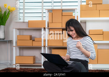 Bezaubernd schöne asiatische Teenager Eigentümer Geschäftsfrau im Boden sitzen für Online Shopping, suchen und um Laptop und mit Office eq aufgeregt Stockfoto