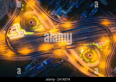 Luftaufnahme von Autobahnkreuzen Blick von oben auf die Stadt bei Nacht, Bangkok, Thailand. Leichte Wanderwege über Kreuzung, Verkehr Abstract und Transport Stockfoto