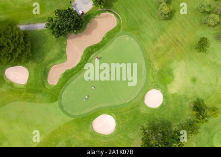 Luftaufnahme der Spieler auf einem grünen Golfkurs. Golfspieler spielen auf Putting Green im Sommer. Menschen Lebensstil erholsame Zeit im Sport Feld oder vacat Stockfoto
