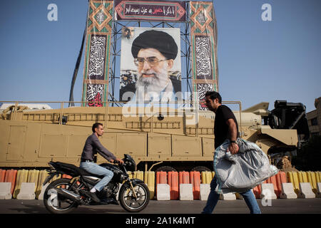 Teheran, Iran. 26 Sep, 2019. Die Shahab-3-Rakete ist auf dem Display neben einem Porträt der iranische Führer Ajatollah Ali Khamenei an einer Ausstellung, die von der Iranischen Revolutionären Garde feiert "Heilige Verteidigung Woche"-Kennzeichnung der 39. Jahrestag des Beginn des Iran-Irak-Kriegs, 1980-88 an der Baharestan Square in Teheran, Iran. Die Spannungen zwischen Iran und den USA weitergeht, der iranische Präsident Hassan Rohani sagte in seiner Rede auf der 74. Tagung der Generalversammlung der Vereinten Nationen in New York, dass der Iran nicht mit den USA unter Druck und Sanktionen zu verhandeln. (Credit Stockfoto