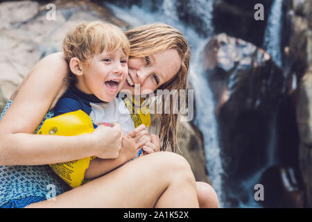 Mutter und junger Sohn auf dem Wasserfall Hintergrund. Reisen mit Kindern Konzept Stockfoto